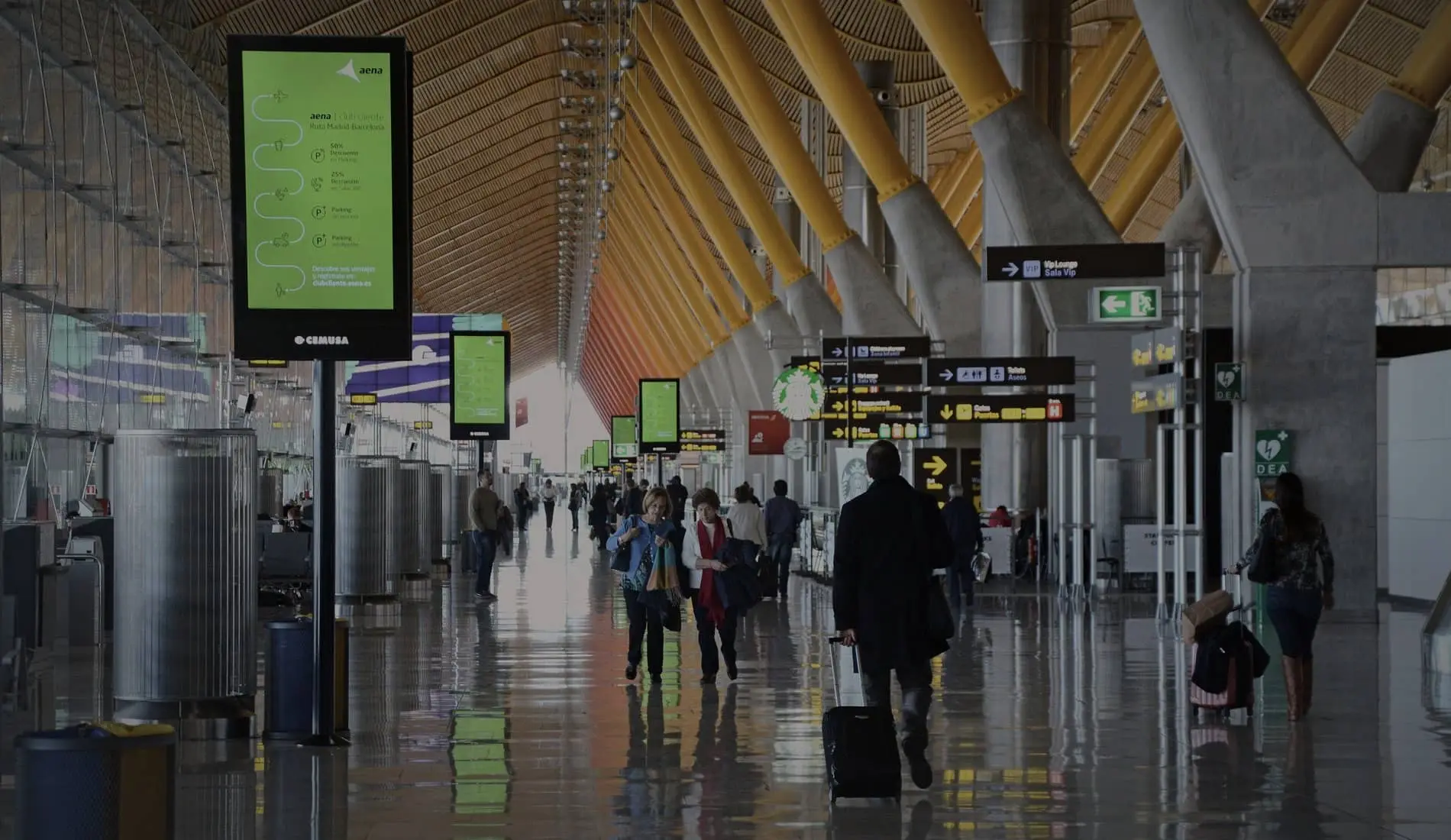 Viajeros con maletas en la terminal T4 del aeropuerto de Madrid-Barajas