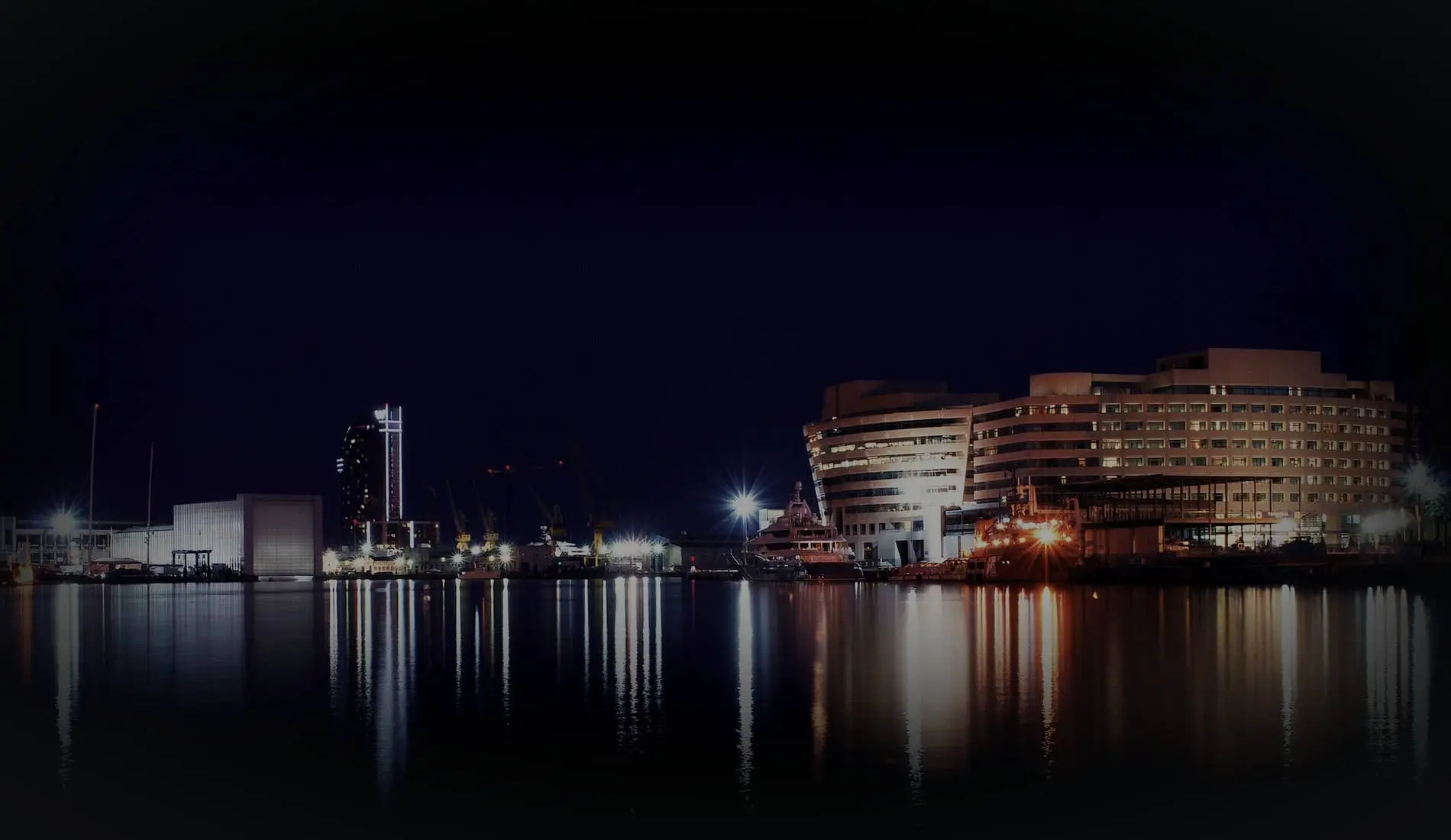 El World Trade Center del puerto de Barcelona reflejado en el agua de noche