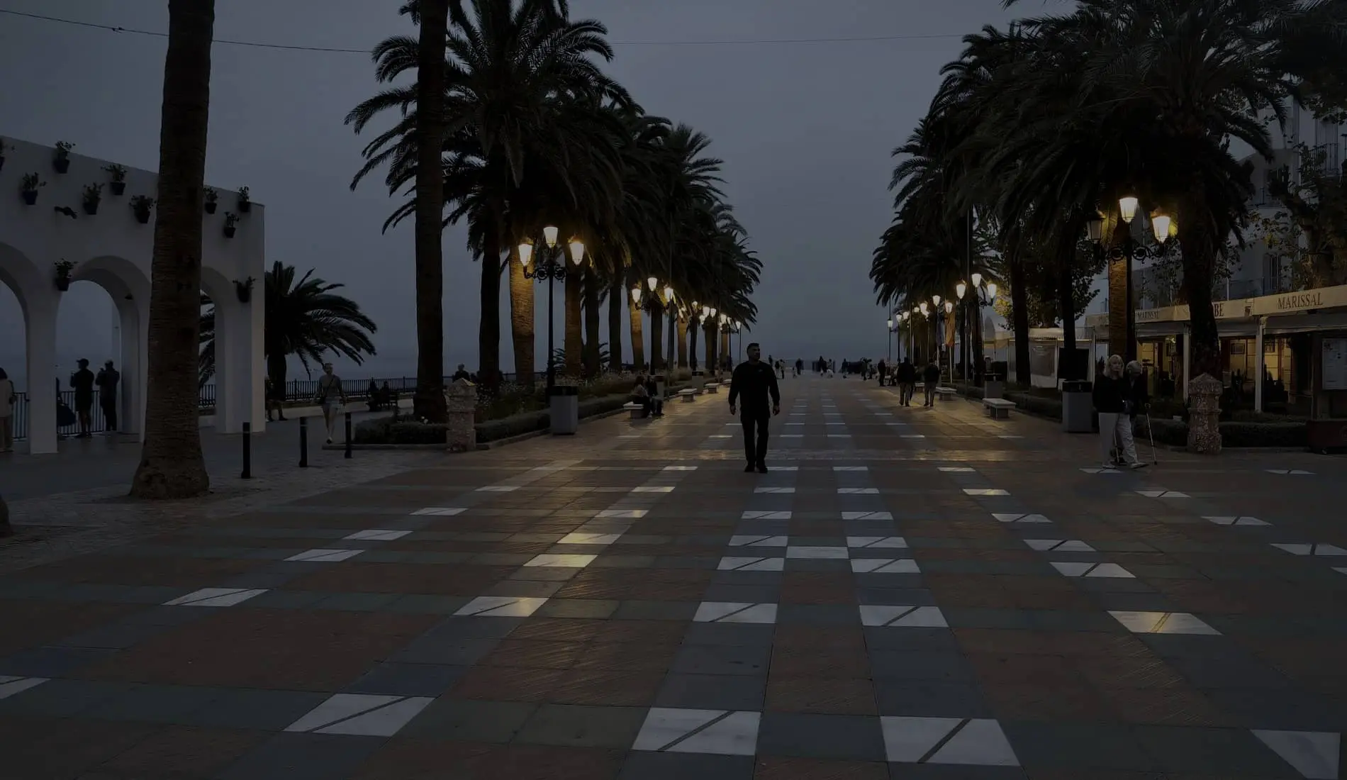 The palm-lined promenade of the Balcón de Europa in Nerja, on the Costa del Sol, at dusk